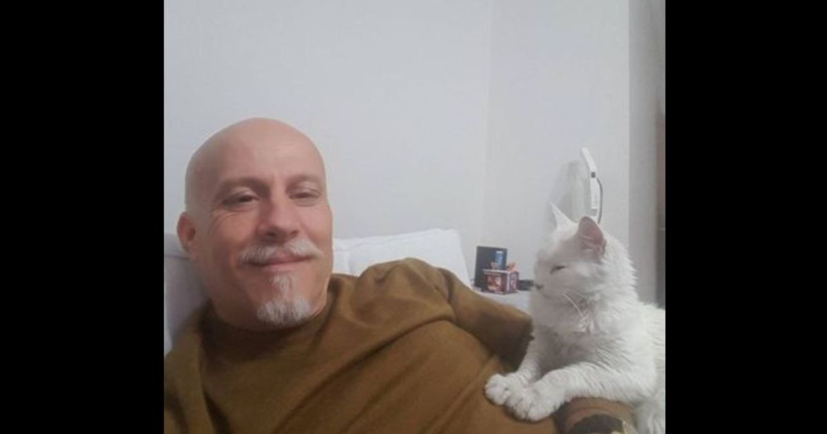 Uomo con gatto sul letto